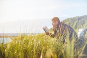 man reading in field
